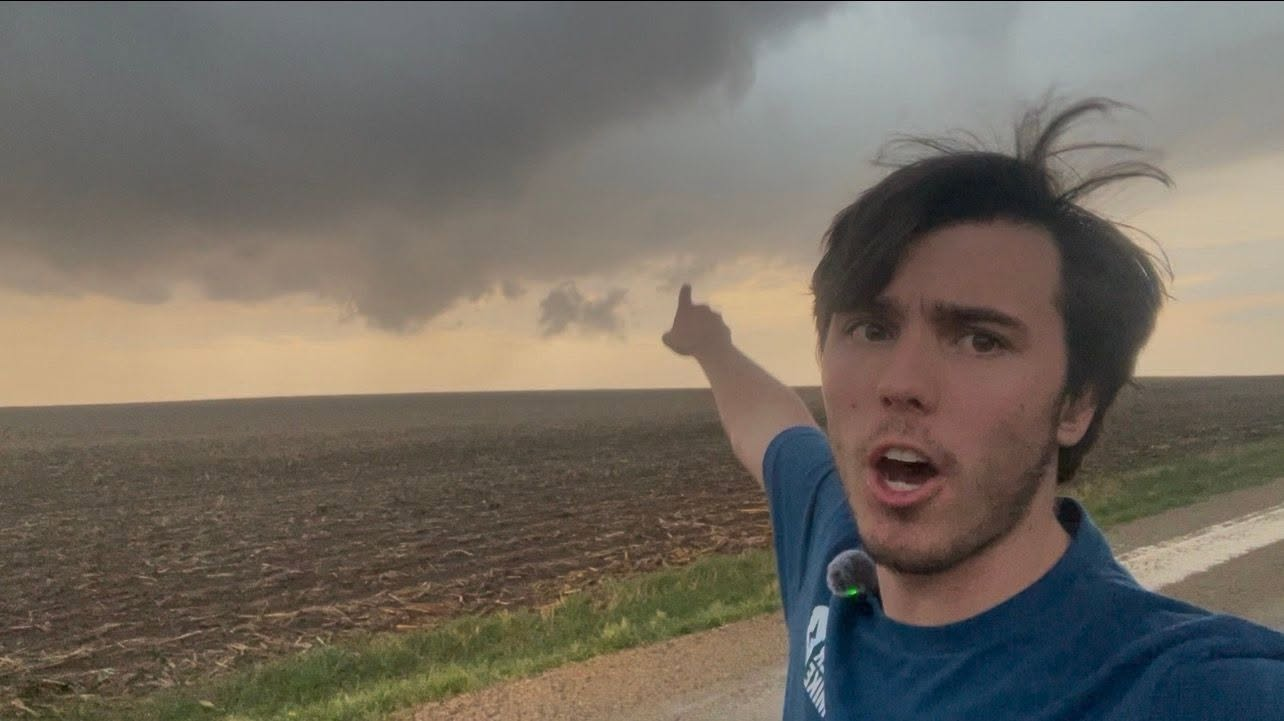 Mikey Plemmons reporting from the road with a storm behind him